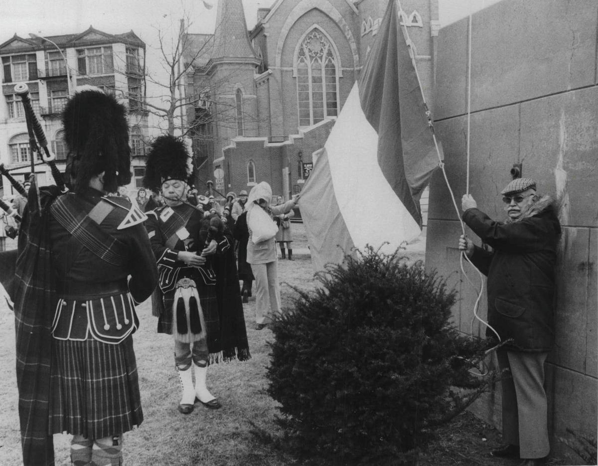 St Patrick's Day. Bagpipers John Crandall and Jim Walsh pipe as Irish flag is raised by Tom Ashe, president AOH, Schenectady, New York, for St Patrick's Day. Joan Glenn (arm in sling holding end of flag) made the flag in 1966 for Mike Lennon, past president. March 17, 1978 (Bud Hewig/Times Union Archive)