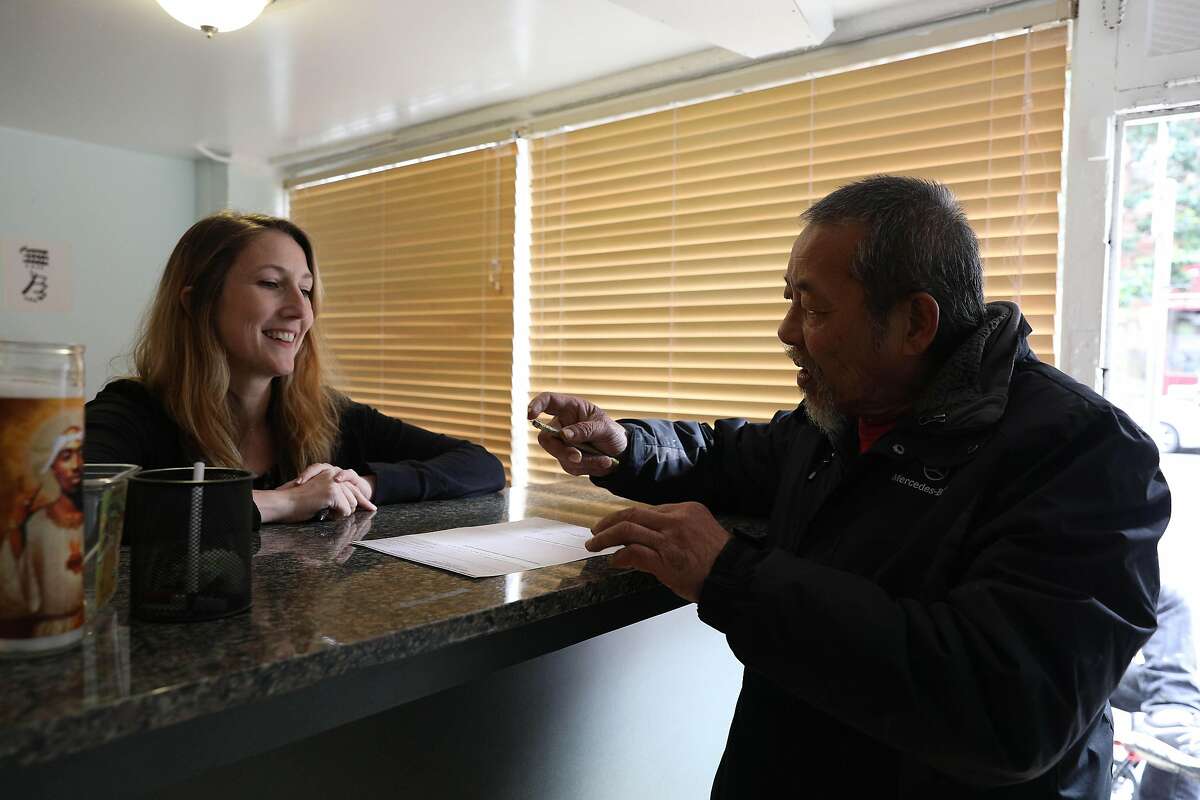 Rachel Rodriguez (l to r), director and co-founder Community Payee Partnership, talks with client Louie Yip as he picks up a check at a Community Payee Partnership office on Thursday, March 7, 2019 in San Francisco, Calif.