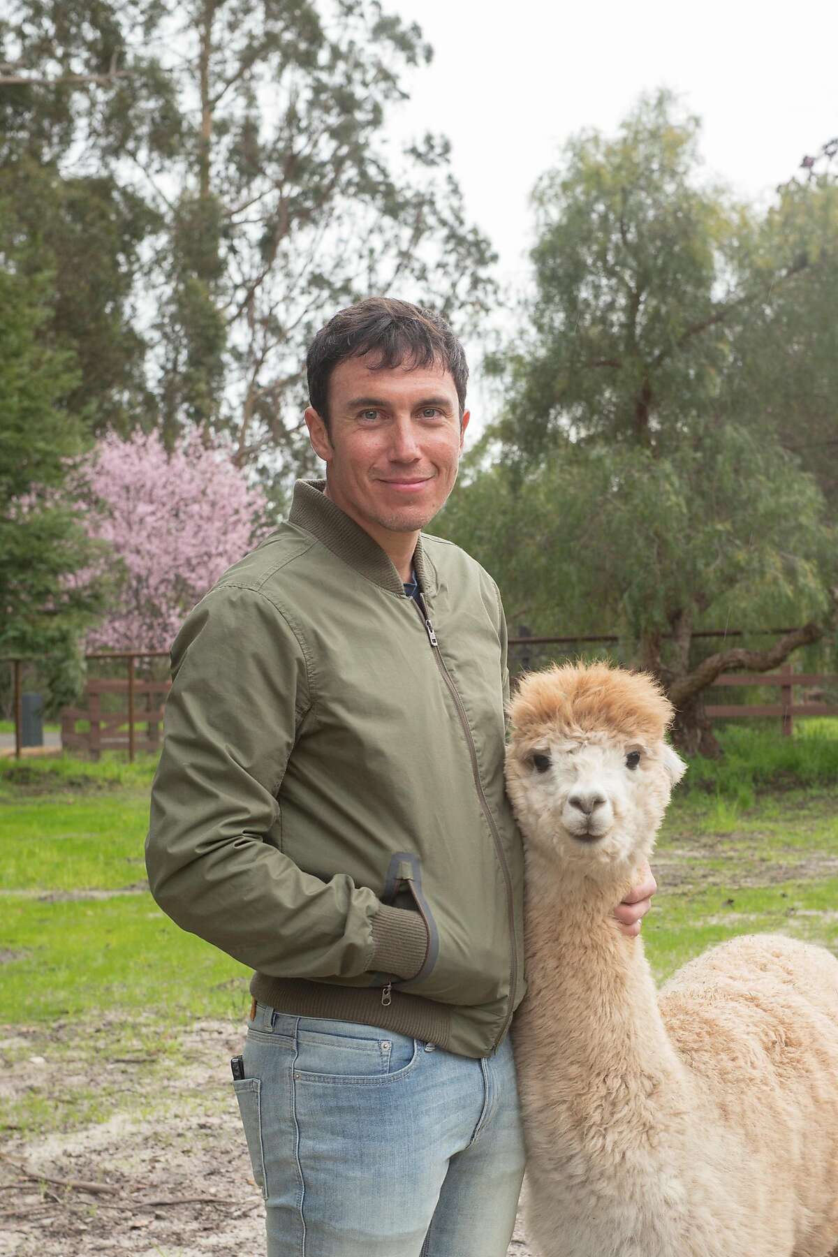 Photographer Chris Burkard with one of his two pet alpacas at his home in Arroyo Grande, Calif.