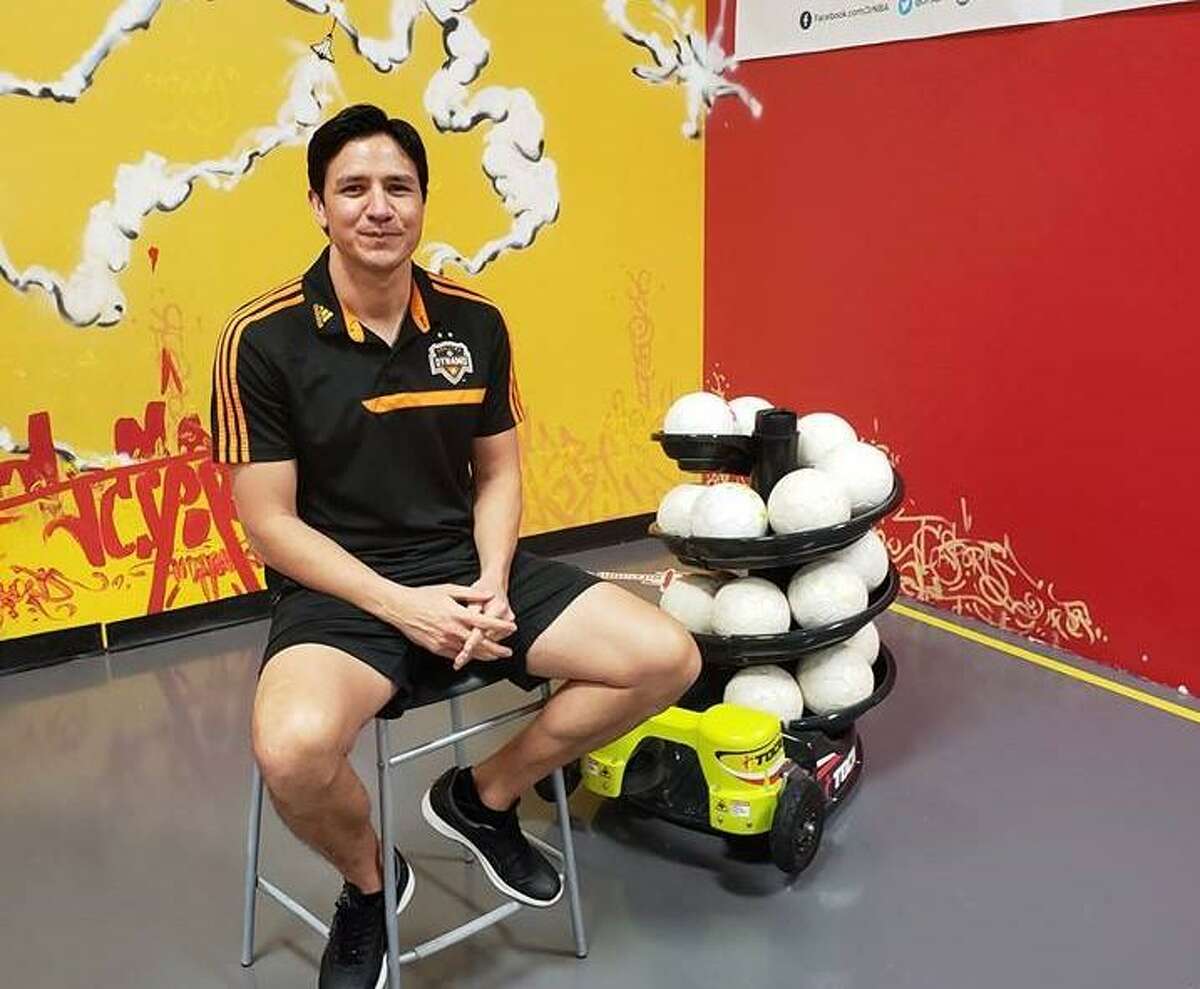 Former Houston Dynamo player Brian Ching poses next to a TOCA touch trainer.