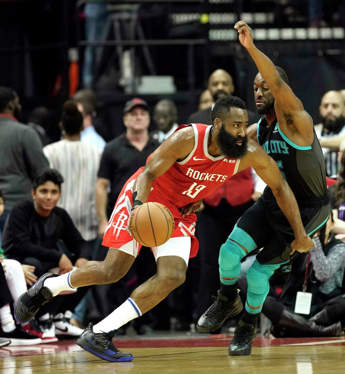Houston Rockets' James Harden (13) drives toward the basket as Charlotte Hornets' Kemba Walker defends during the first half of an NBA basketball game Monday, March 11, 2019, in Houston. (AP Photo/David J. Phillip)