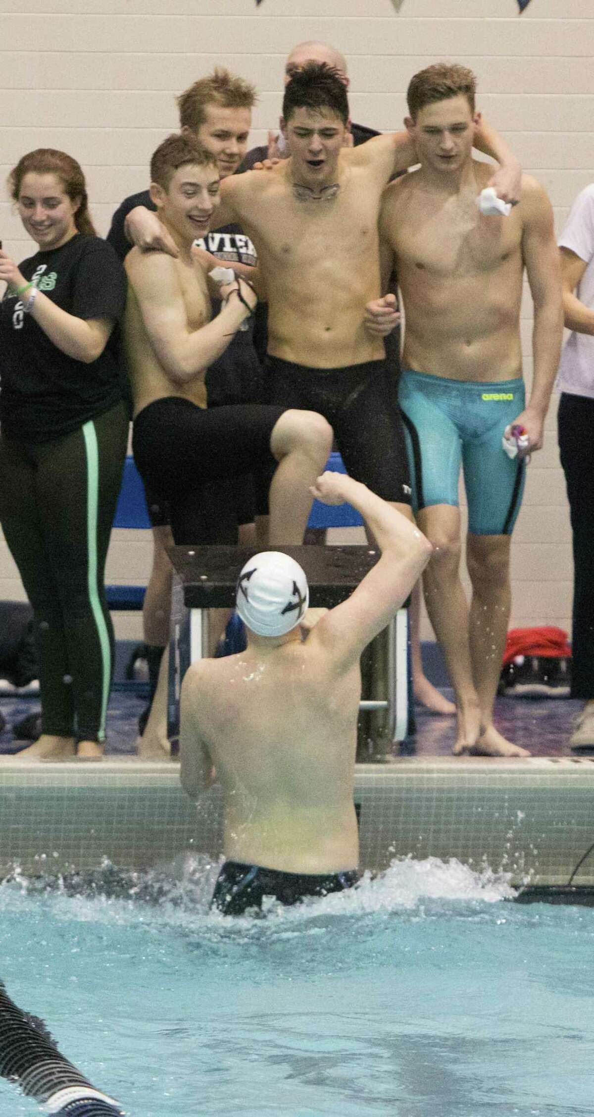 (John Vanacore/For Hearst Connecticut Media) Team members of the Xavier 200 yard medley relay team celelbrate their Class L stat championship Monday night.