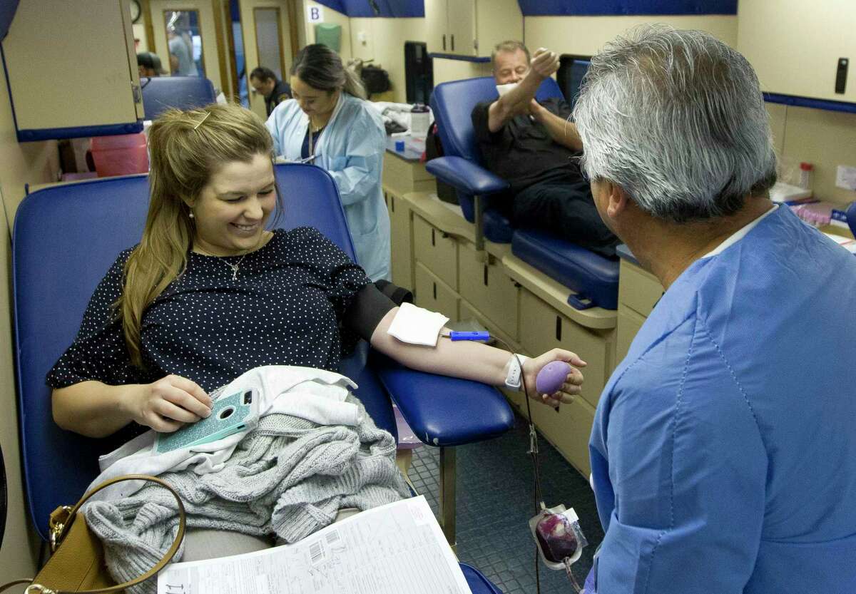 In this file photo from March 12, 2019, Shelby Yow, a Montgomery County Sheriff's detective, is seen with a CHI St. Luke's Health employees as she donates blood in Conroe. The sheriff’s office has a blood drive scheduled for next week.