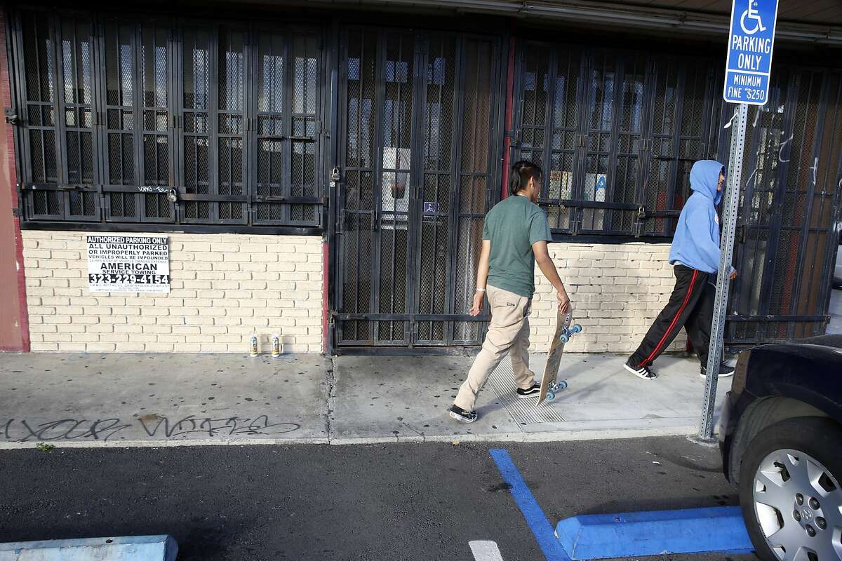 Youngsters walk by the scene of a fatal shooting in Los Angeles, Sunday, March 10, 2019. University of Southern California student Victor McElhaney, the son of an Oakland, Calif., city councilwoman, was shot and killed in an apparent robbery attempt near the USC campus, officials said. (AP Photo/Damian Dovarganes)