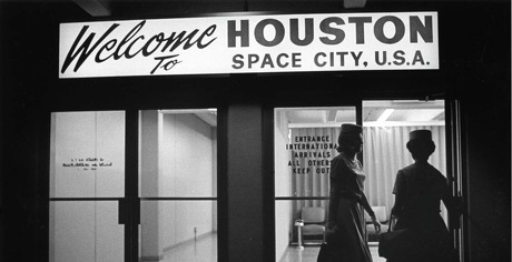Flight attendants enter the international arrivals area at Hobby Airport in December 1967. Arrivals are greeted with a "Welcome to HOUSTON SPACE CITY, U.S.A." sign over the door.