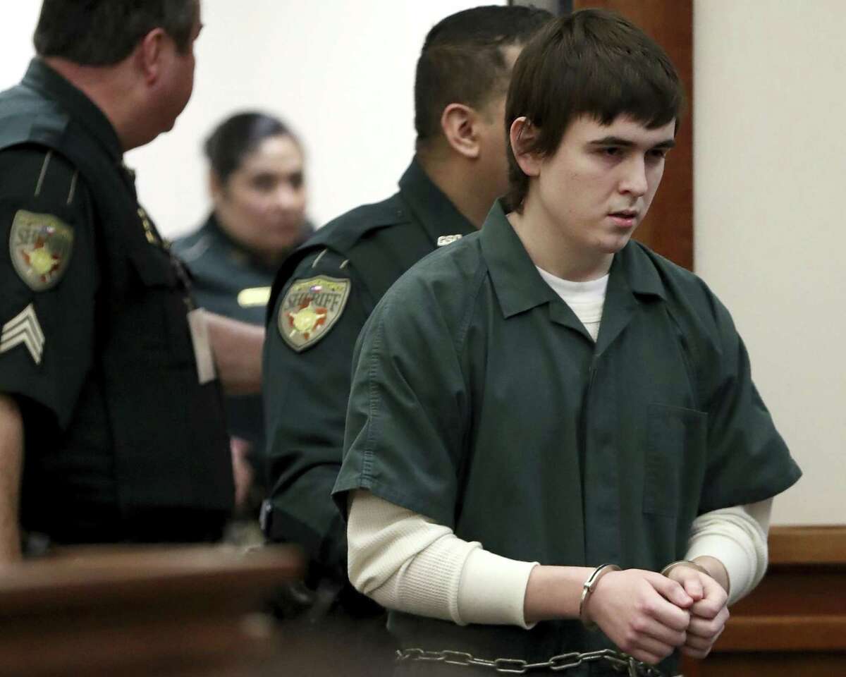 FILE - In this Feb. 25, 2019 file photo Dimitrios Pagourtzis, the Santa Fe High School student accused of killing 10 people in a May 18 shooting at the high school, is escorted by Galveston County Sheriff's Office deputies into the jury assembly room for a change of venue hearing at the Galveston County Courthouse in Galveston, Texas. A judge has ordered Pagourtzis' trial be moved to another county. State District Judge John Ellisor granted Pagourtzis' request for a venue change Wednesday, Feb. 28, 2019. (Jennifer Reynolds/The Galveston County Daily News via AP, Pool)