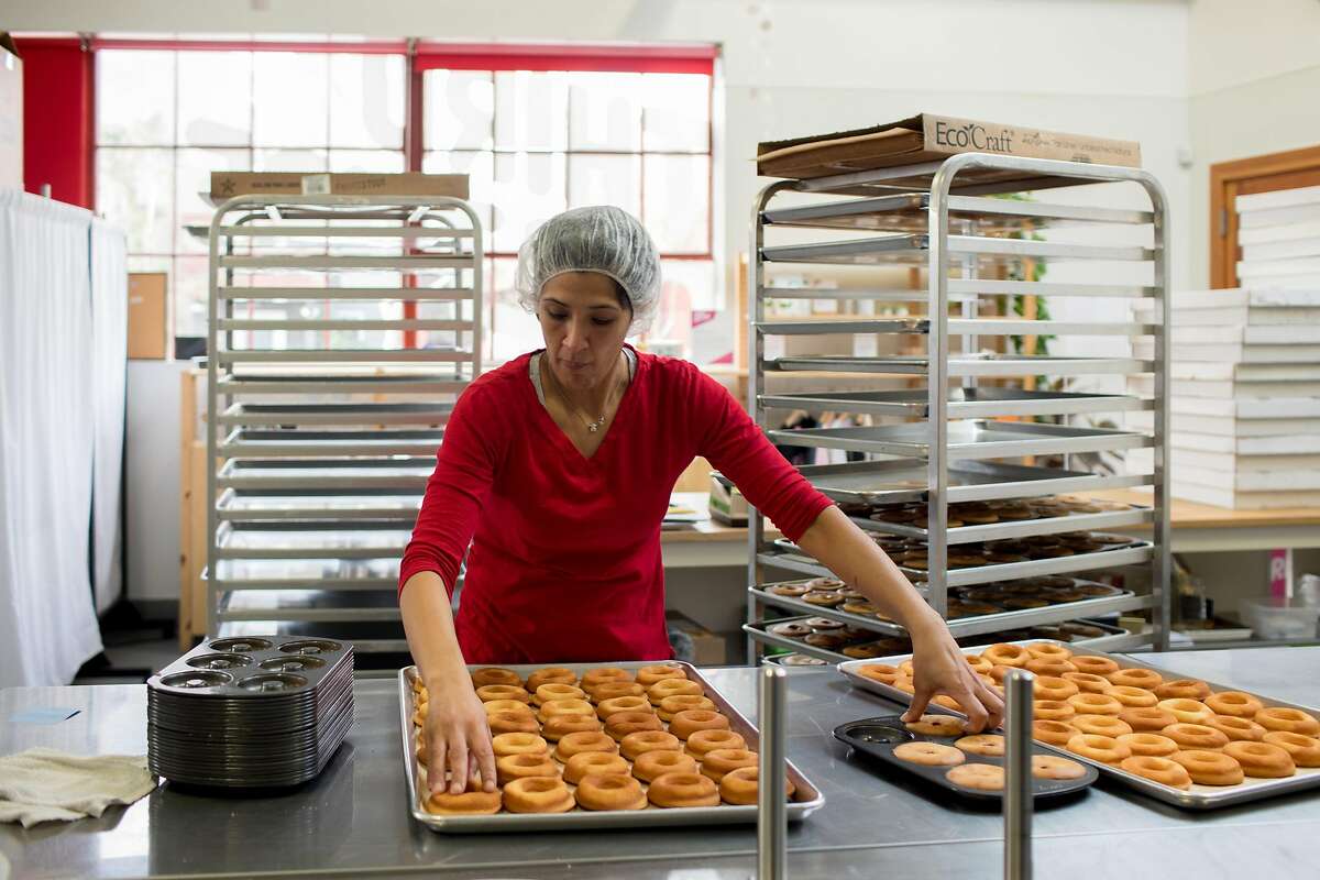 Kitchen manager Diana Sanchez removes baked mochi donuts from pans at Third Culture Bakery in Berkeley, Calif. on Sunday, January 27, 2019.