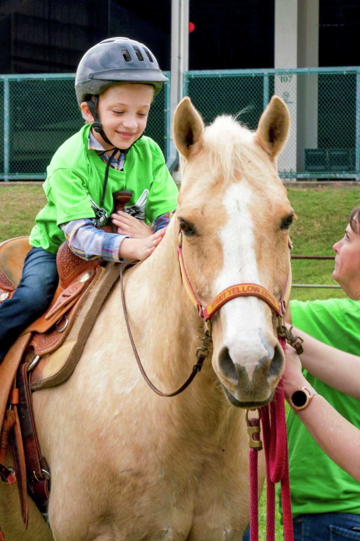 A participant of the 4th Annual Montgomery County 4-H Angels Rodeo takes a ride on a horse as a part of the event.