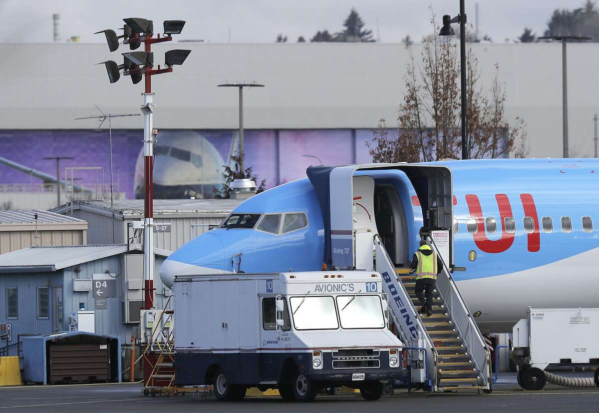 A worker walks up steps to the right of an avionics truck parked next to a Boeing 737 MAX 8 airplane being built for TUI Group at Boeing Co.'s Renton Assembly Plant Wednesday, March 13, 2019, in Renton, Wash. President Donald Trump says the U.S. is issuing an emergency order grounding all Boeing 737 Max 8 and Max 9 aircraft in the wake of a crash of an Ethiopian Airliner. (AP Photo/Ted S. Warren)