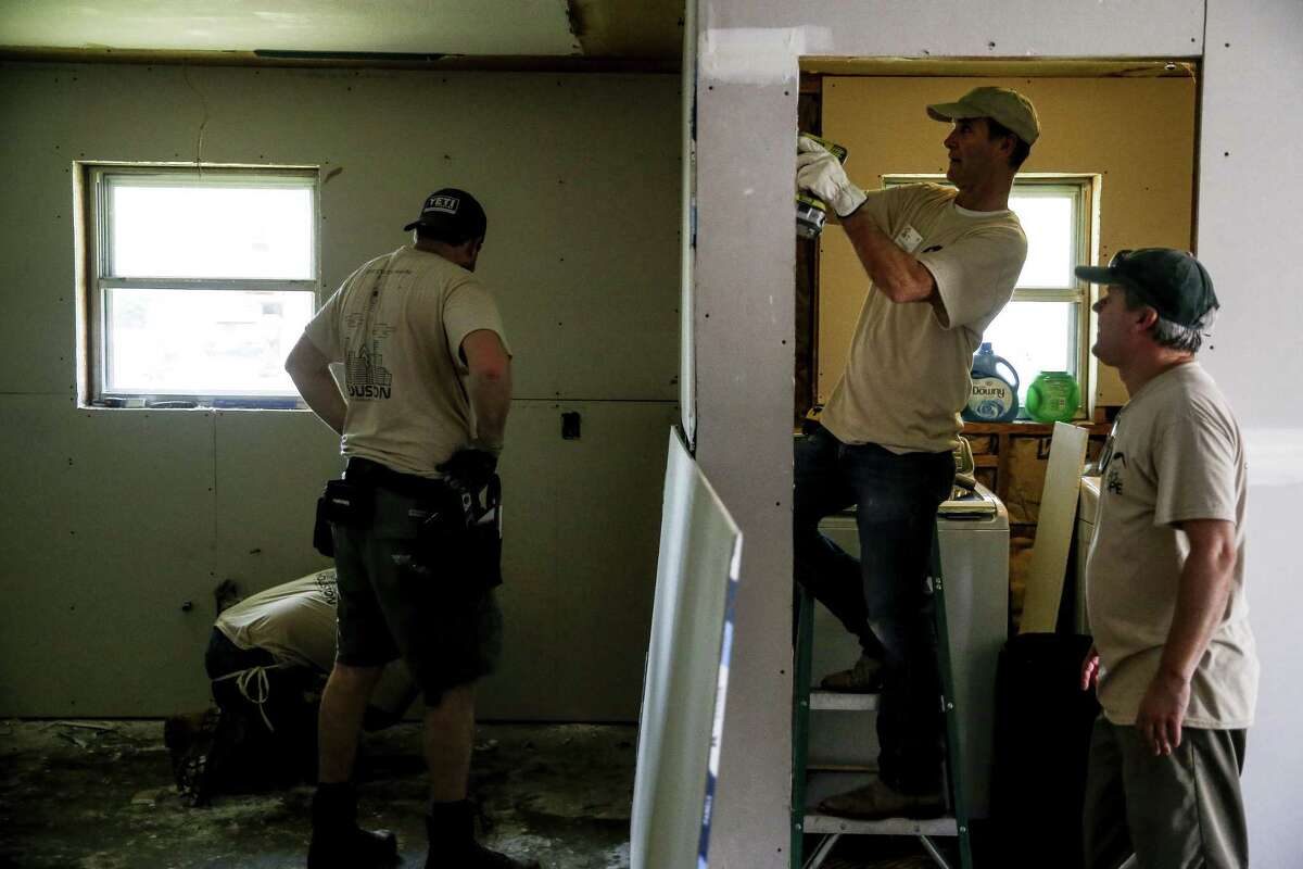 Eight Days of Hope volunteer David Buttram, second from right, puts up drywall as he works to repair the laundry room of a home flooded by Hurricane Harvey Saturday, March 10, 2018 in Dickinson. Thousands of volunteers spread out across the Houston area to help more than 500 homeowners repair or rebuild their homes in the wake of the hurricane. (Michael Ciaglo / Houston Chronicle)