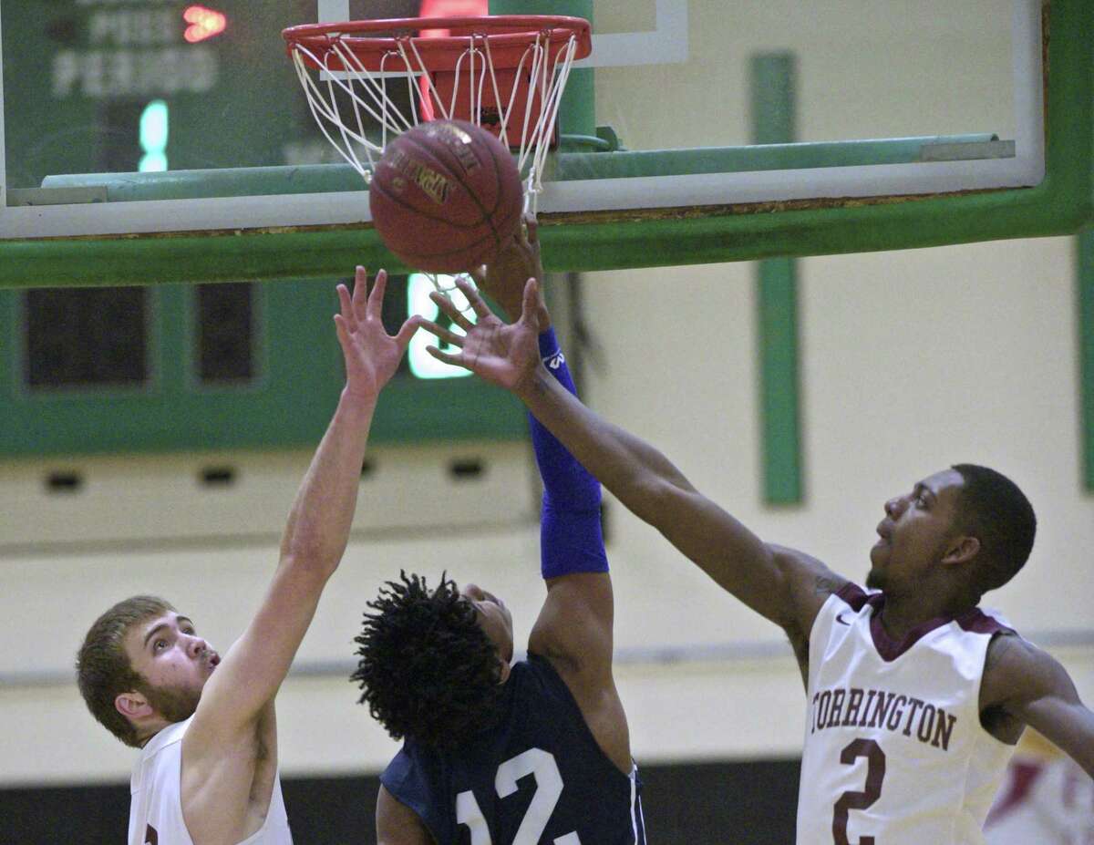 Amistad’s Cyprin Joseph (12) goes up to the basket between Torrington’s Kevin Dixon, left, and Ty Davis (2) in the CIAC Division III boys basketball semifinal game Wednesday at Wilby High School in Waterbury.