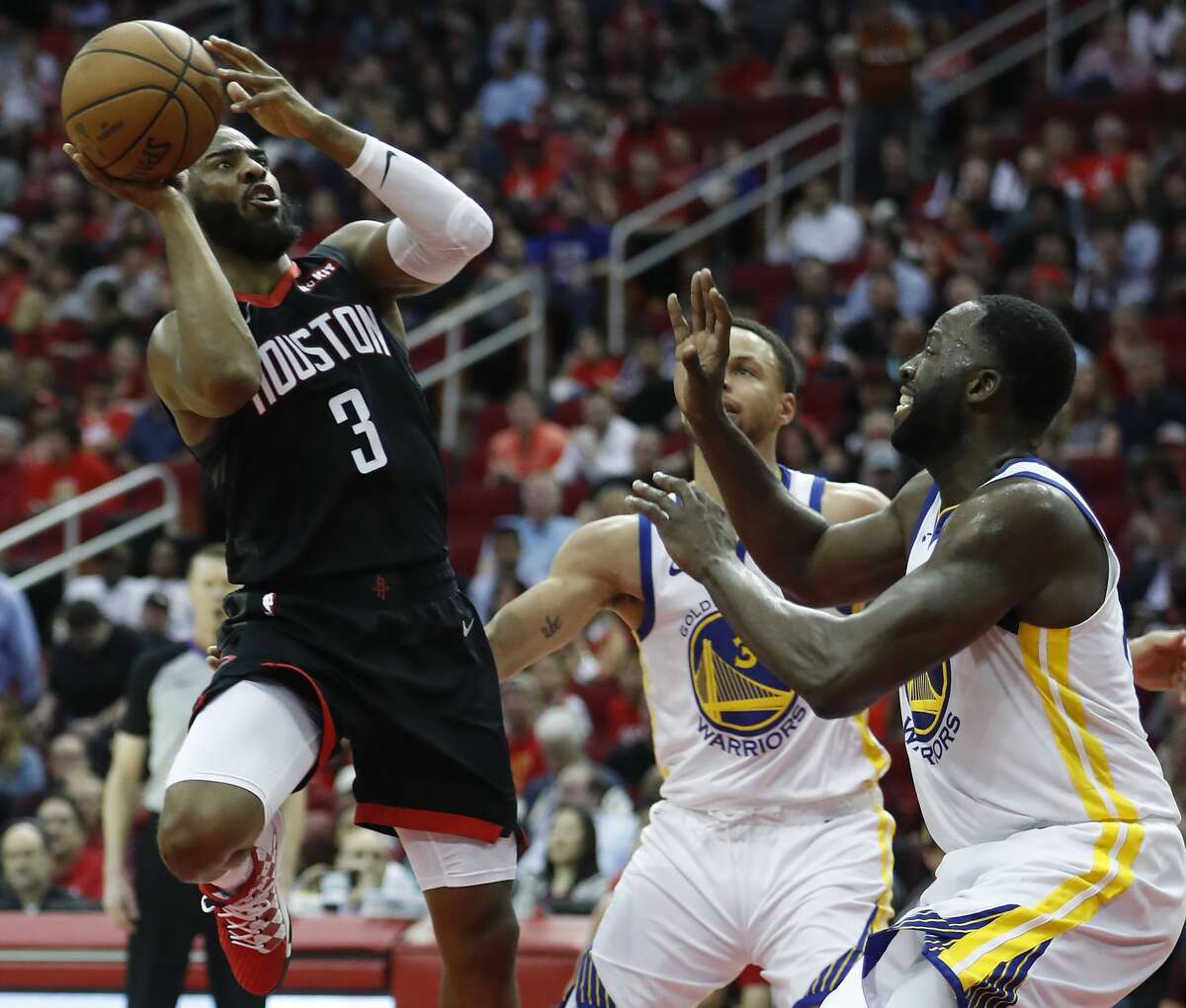 Houston Rockets guard Chris Paul (3) takes a shot against Golden State Warriors guard Stephen Curry (30) and forward Draymond Green (23) during the third quarter of an NBA basketball game at Toyota Center on Wednesday, March 13, 2019, in Houston.