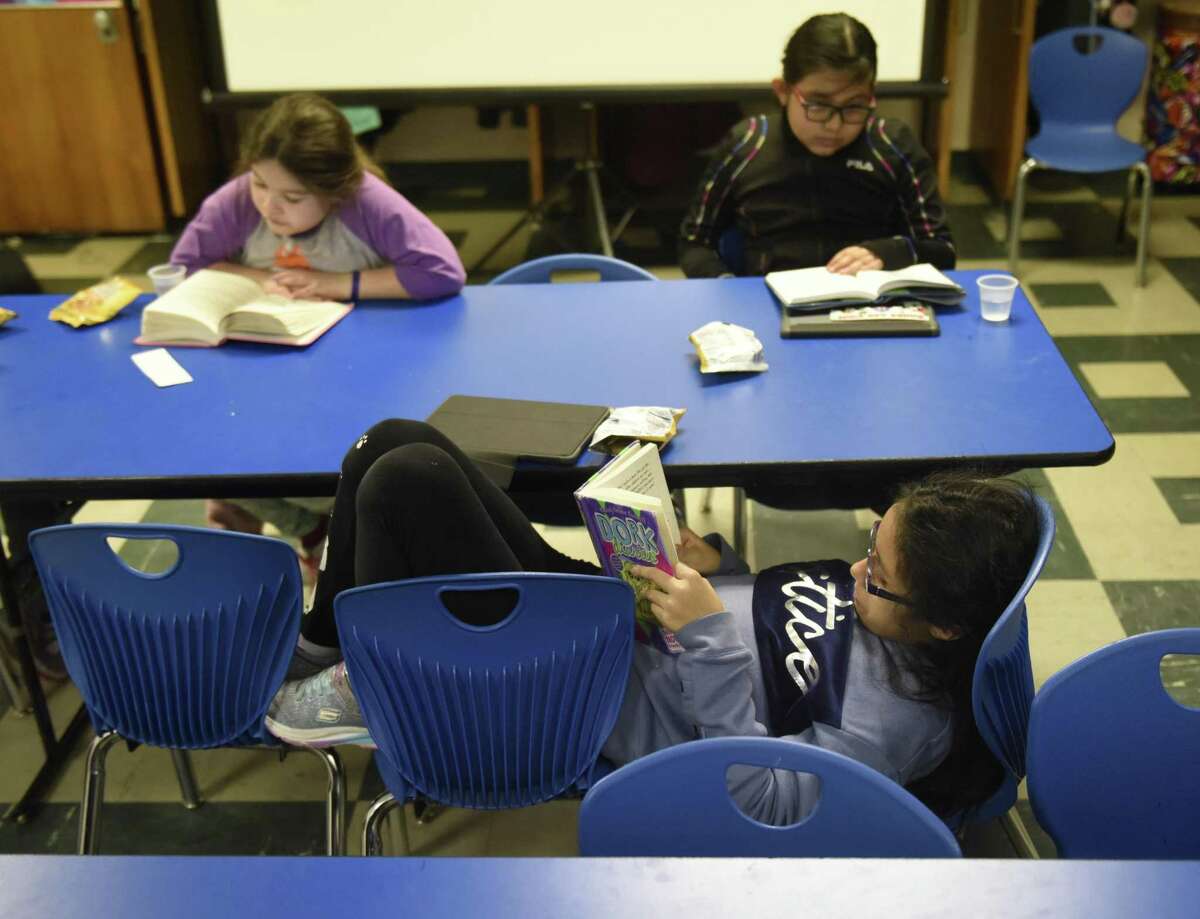 Johana Cojitambo, 10, reads quietly at Family Centers' Family First in Education program at the YMCA Early Learning Center in the Chickahominy section of Greenwich, Conn. Tuesday, Jan. 29, 2019. The program attempts to bridge the socio-economic opportunity gap by offering an after school tutoring service and home visits to ensure parents get involved with their children's educations.
