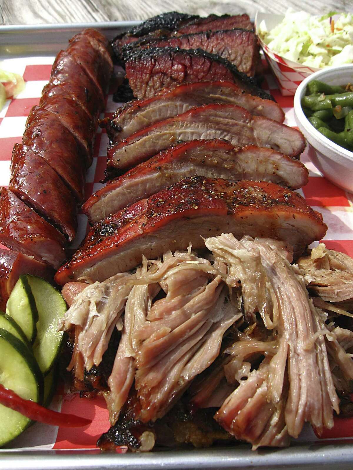 Clockwise from left: sausage, brisket, cole slaw, green beans, pulled pork and housemade pickles from Burnwood '68