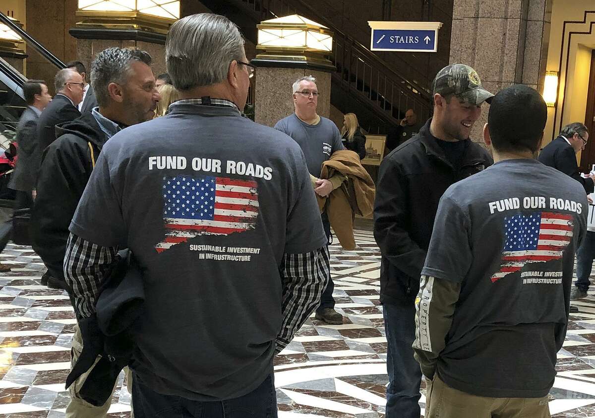 Members of The International Union of Operating Engineers, Local 478, wear shirts supporting tolls for road funding as hundreds of people on both sides of the issue turned out Wednesday, March 6, 2019, for a legislative hearing at the Capitol in Hartford, Conn., on whether Connecticut should institute electronic highway tolls. The turnout highlighted the strong divide that's developed over an issue being pushed hard by the state's new Democratic Gov. Ned Lamont. (AP Photo/Susan Haigh)