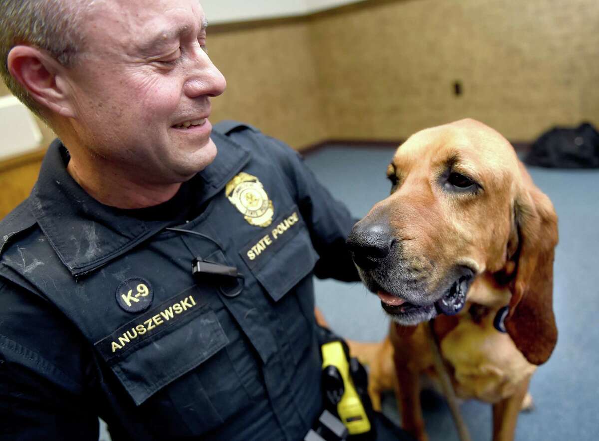 Connecticut State Police Trooper 1st Class Edward Anuszewski is photographed with his bloodhound tracking dog, Texas, at the Connecticut State Police Canine Unit Training Center in Meriden on March 11, 2019.