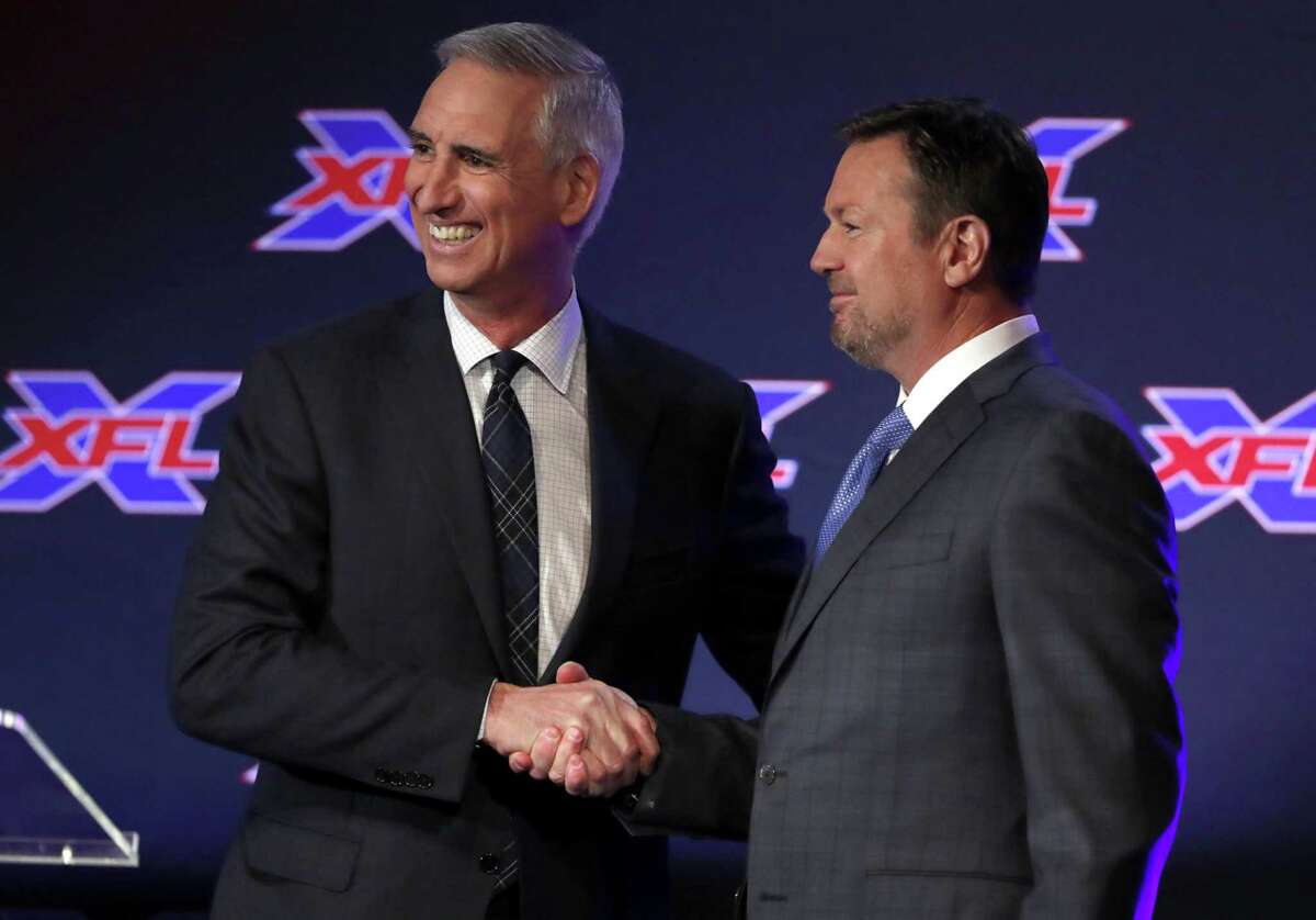 Oliver Luck, XFL Commissioner and CEO greets Bob Stoops after Luck introduced during a news conference as the new general manager and head coach of the Dallas XFL football team in Arlington, Texas, Thursday, Feb. 7, 2019. (AP Photo/Tony Gutierrez)