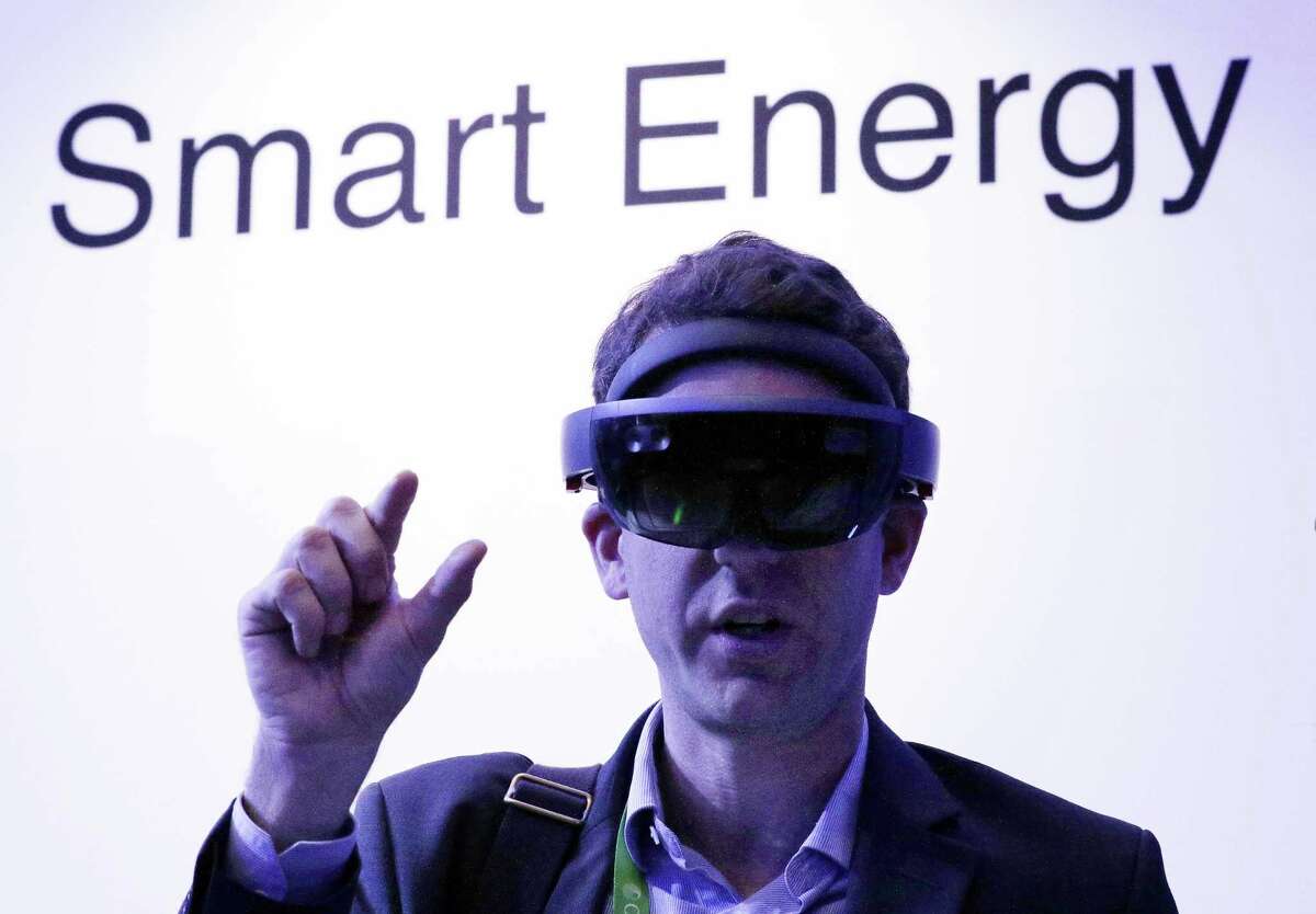 Guillaume de Cumond with Total tries on Microsoft’s augmented reality headset at CERAWeek by IHS Markit in the Microsoft room displaying various energy technologies.