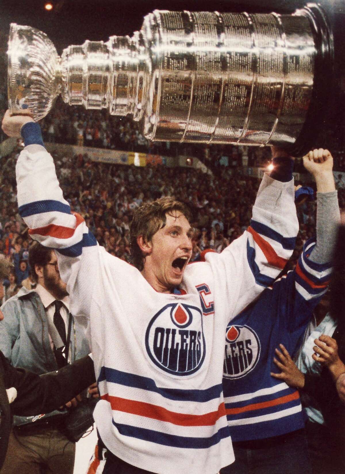 FILE--Edmonton Oilers hockey great Wayne Gretzky screams with joy as he hoists the Stanley Cup over his head following the team's win over the New York Islanders in Edmonton in 1984. Gretzky, 38, promised he won't keep everyone hanging. He said he'll decide by Sunday _ but ``not today or tomorrow'' _ whether to end his 20-year National Hockey League career. (AP Photo/Mike Ridewood) CORRECTED HOUCHRON CAPTION (12/26/1999): Wayne Gretzky was the unquestioned Great One. HOUSTON CHRONICLE SPECIAL SECTION: THE SPORTS CENTURY. HOUSTON CHRONICLE SERIES: THE SPORTS CENTURY.