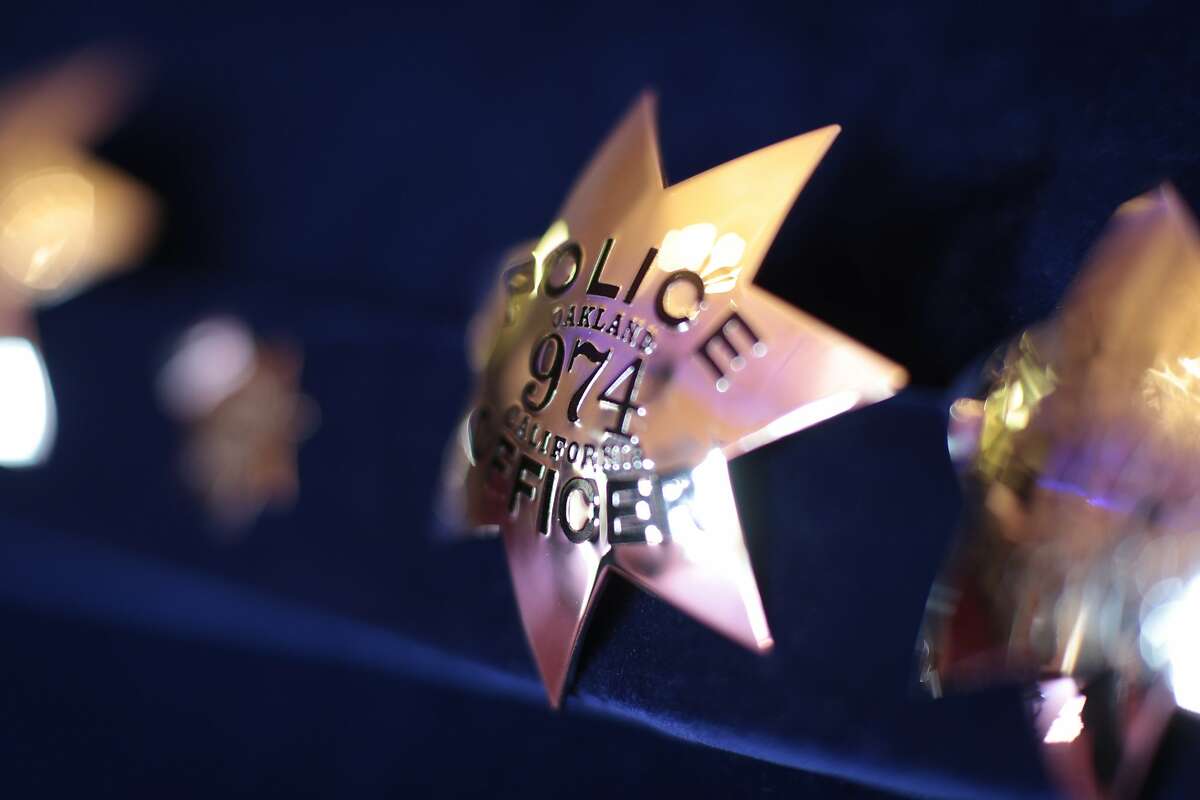 Police badges are on display before the graduation ceremony begins on Friday, Oct. 30, 2015 in Oakland, Calif. The 172nd police academy of Oakland celebrates graduation at the Scottish Rite Temple.