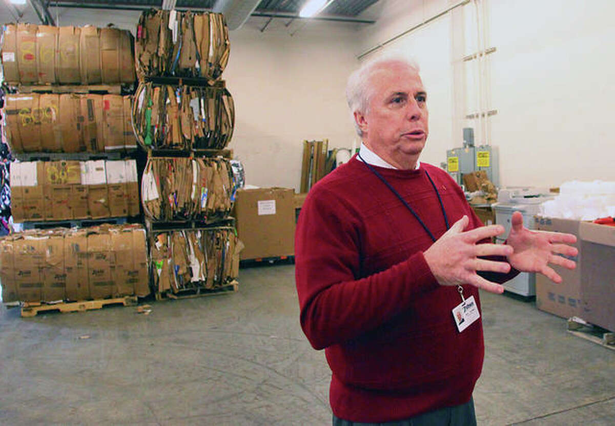 With bales of recyclable materials in the background, Pathway Services Unlimited Executive Director Steve Brundage describes how the operation will go forward in a reduced capacity.
