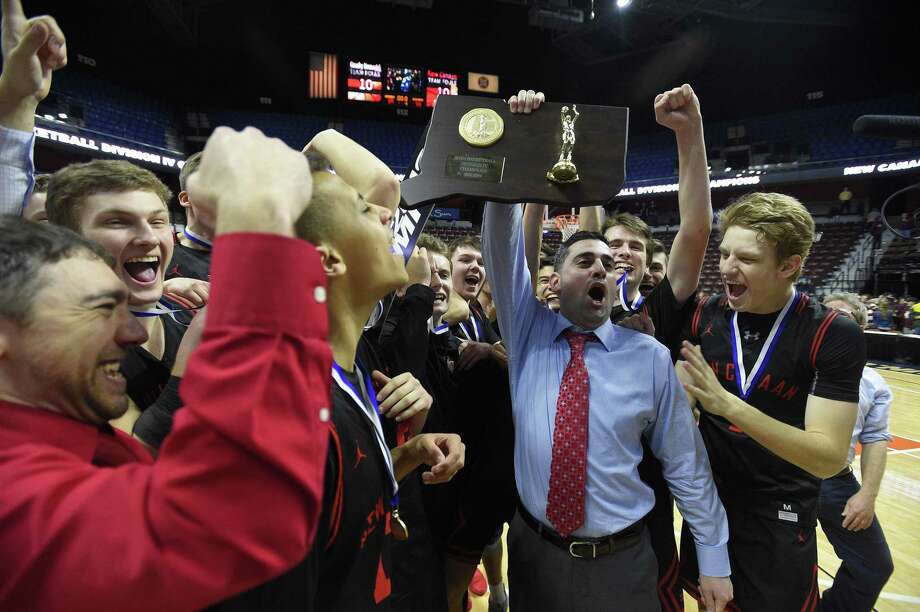 New Canaan coach Danny Melzer holds up the championship plaque with his team after defeating Granby on Saturday. Photo: Matthew Brown / Hearst Connecticut Media / Stamford Advocate