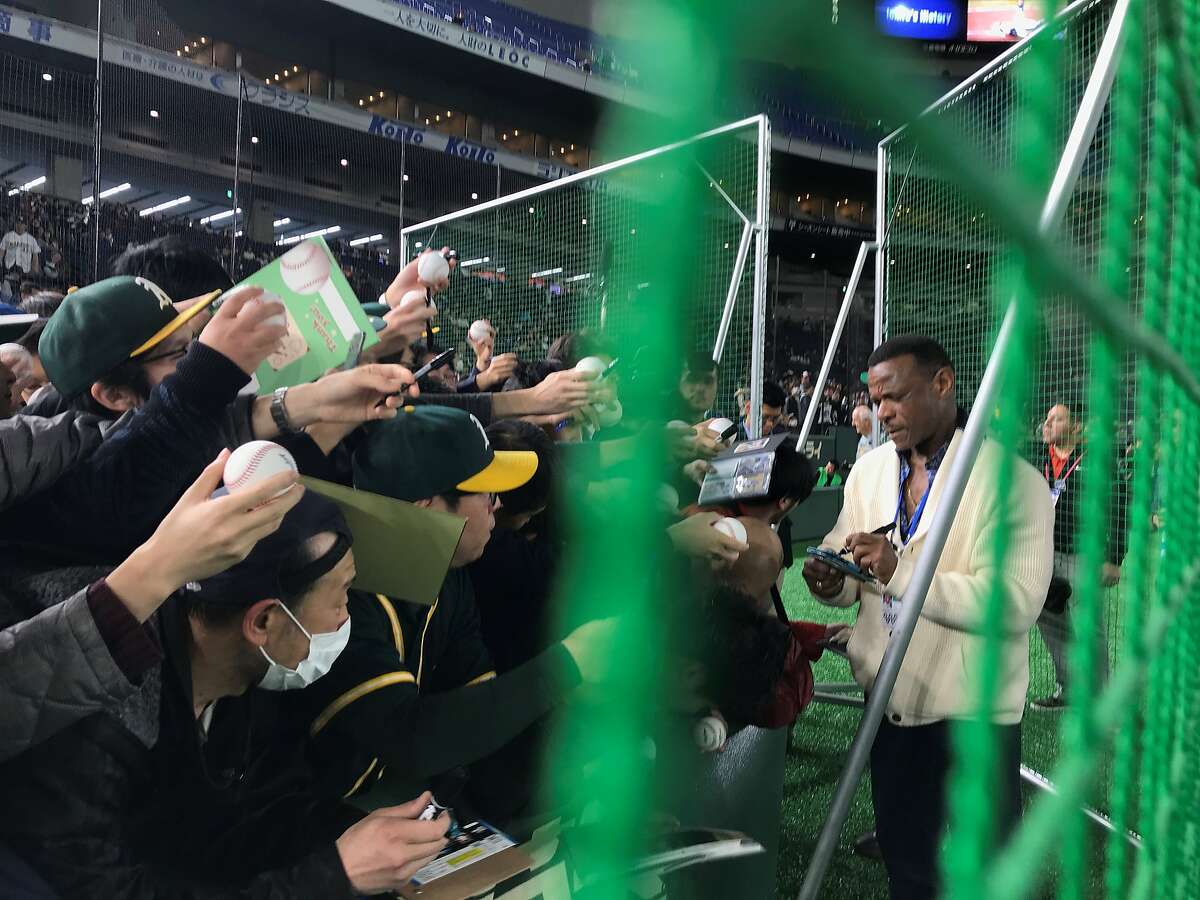A's Hall of Famer Rickey Henderson signed autographs during the team's batting practice at the Tokyo Dome on Sunday.