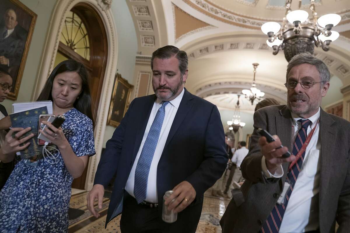 Reporters seek a comment from Sen. Ted Cruz, R-Texas, following a closed-door GOP policy meeting at the Capitol in Washington, Wednesday, March 13, 2019. (AP Photo/J. Scott Applewhite)