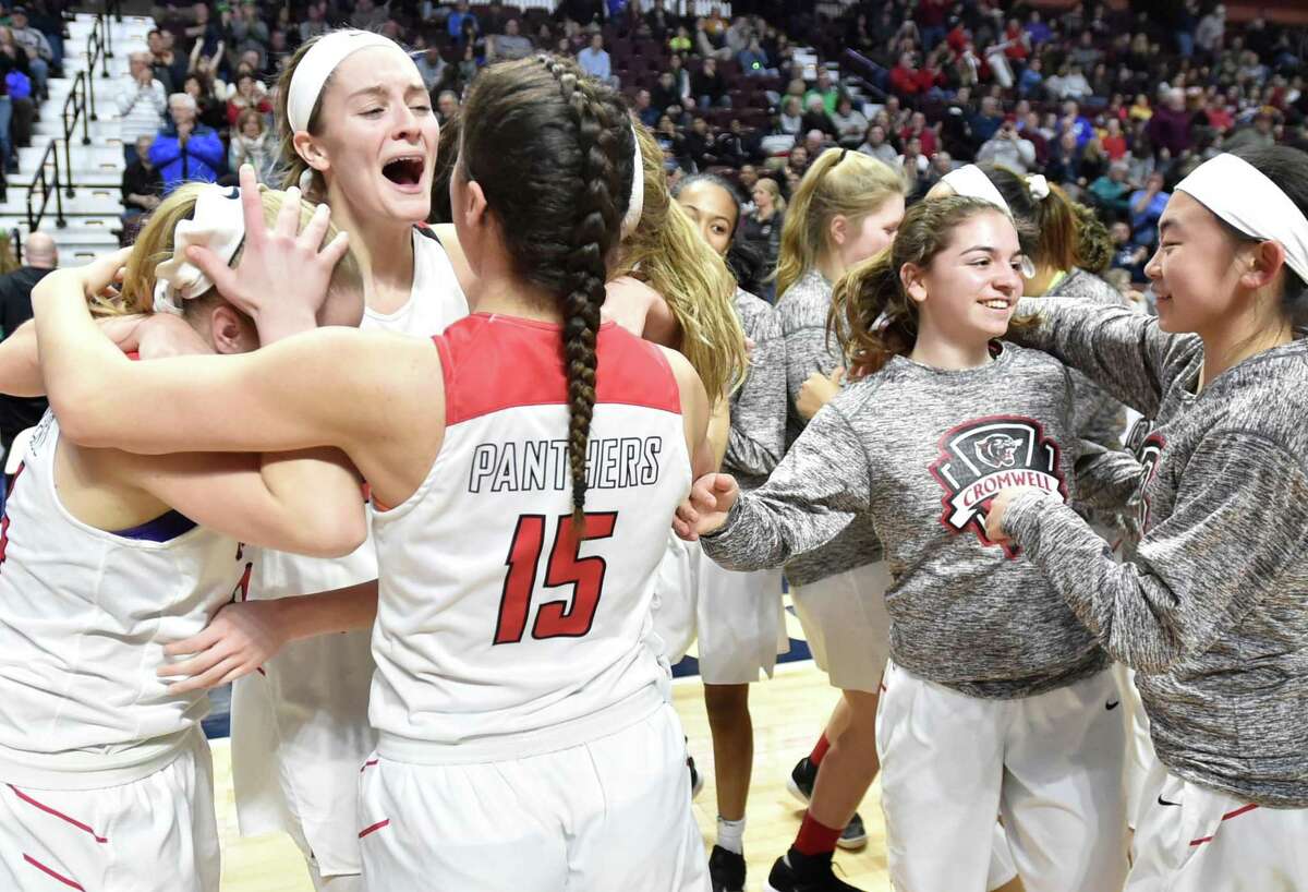 Members of the Cromwell girls basketball team celebrate their win over Sheehan in the Class M championship game on Sunday.