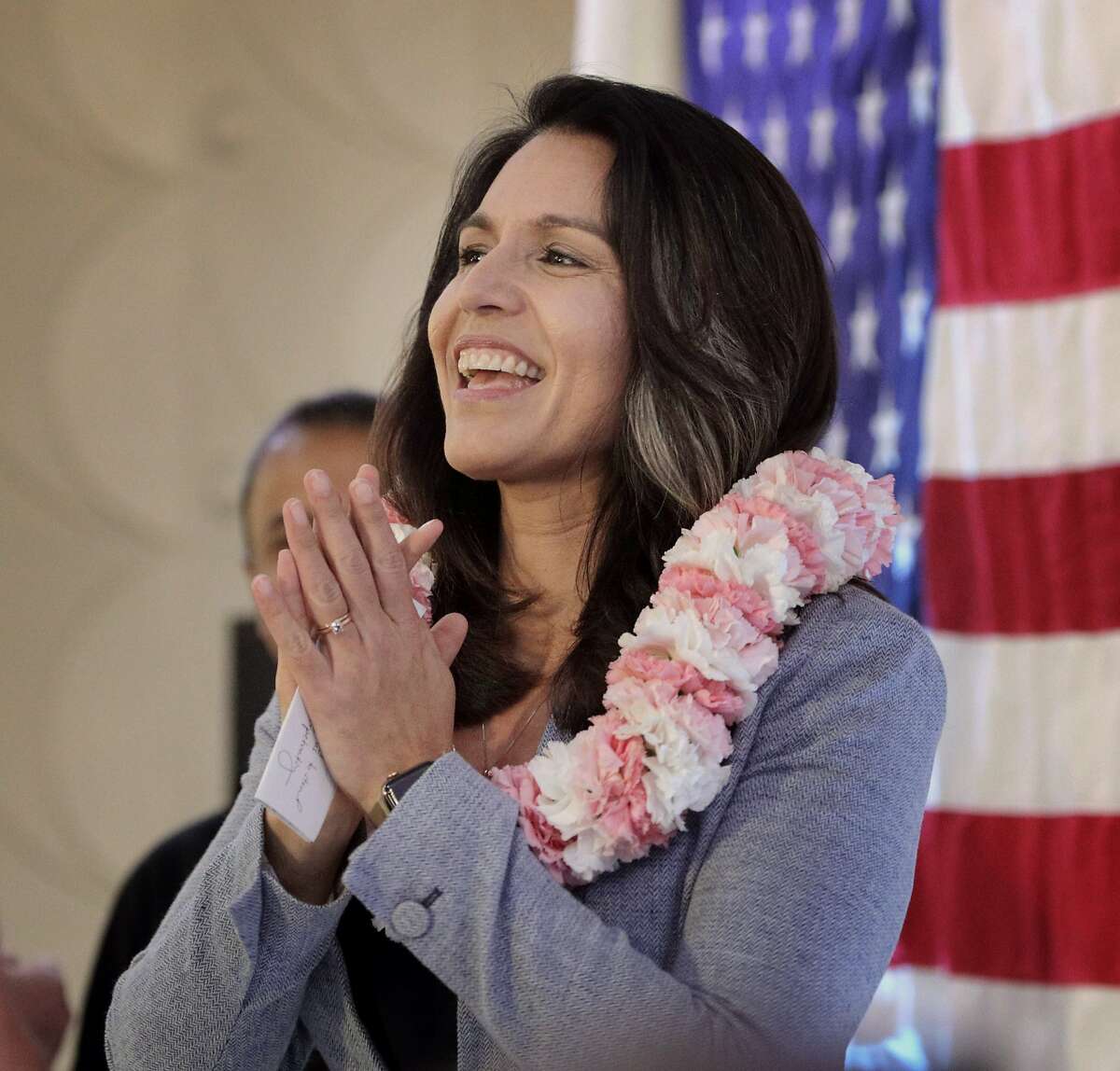 U.S. Rep. Tulsi Gabbard reacts to the applause as she takes the stage during a town hall meeting held by the 2020 candidate for president, in Fremont, Calif., on Sunday, March 17, 2019. Gabbard who represents the 2nd congressional district in Hawaii, is a former veteran and served several tours in Iraq.