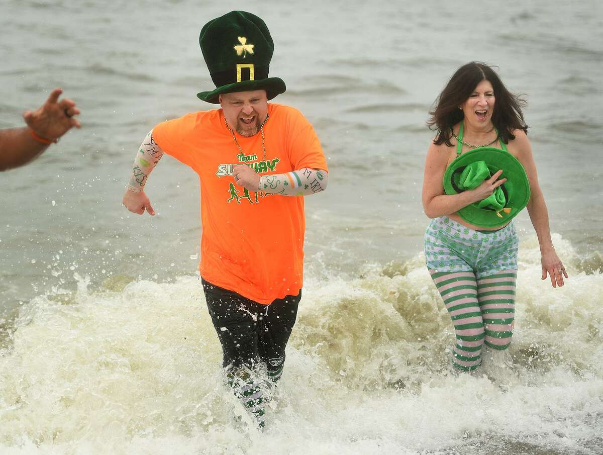 Team Subway members John Sinnott and Paula Kranyak, both of Milford, run from cold waters of the Sound during the Literacy Volunteers of Southern Connecticut's annual Leprechaun Leap at Walnut Beach in Milford, Conn. on Sunday, March 10, 2019.