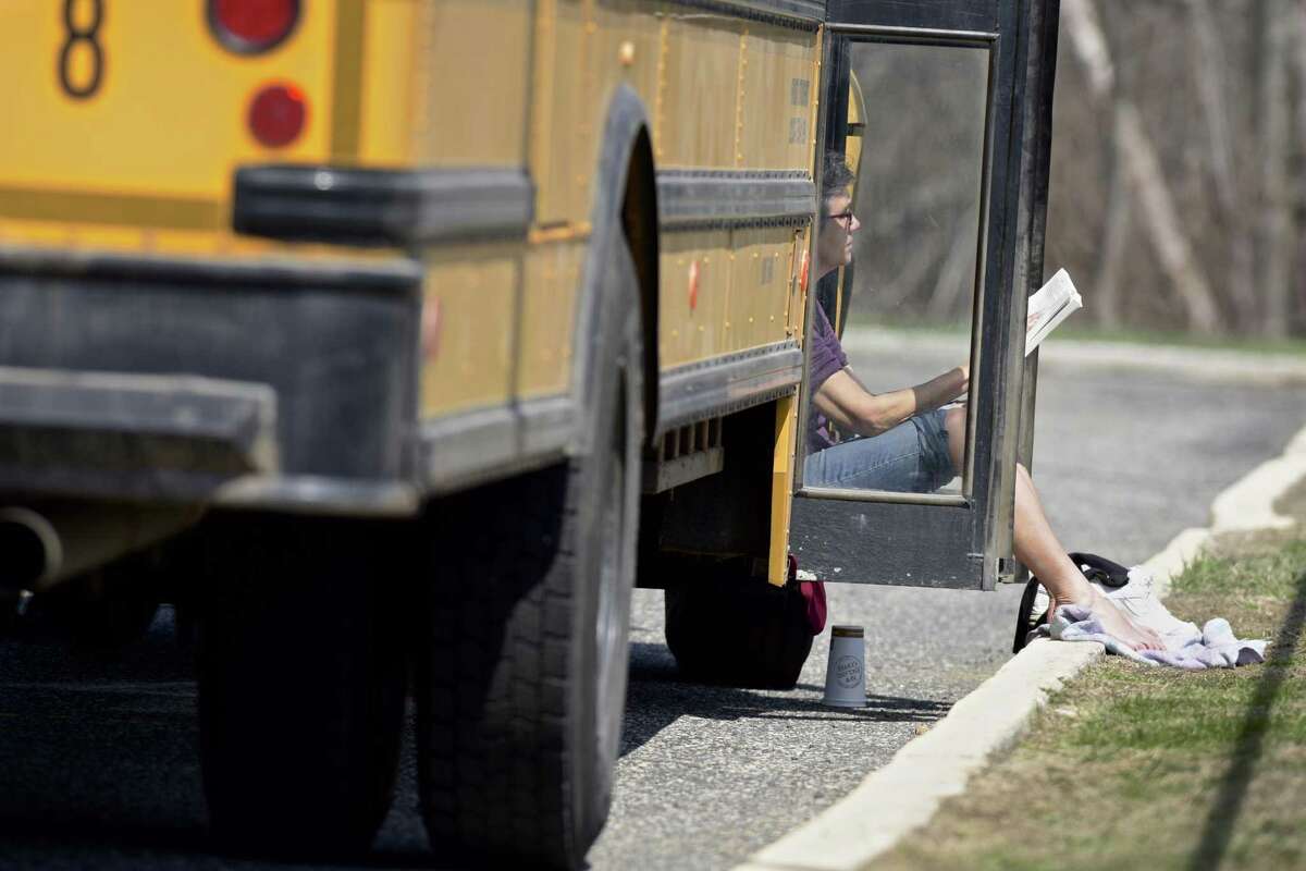 Priscilla Parzuchowski, a bus driver from First Student, reads a book and catches some sun.