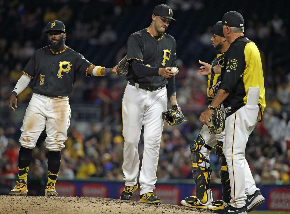 Pittsburgh Pirates relief pitcher Dovydas Neverauskas hands the ball to manager Clint Hurdle in the seventh inning of a game against the Philadelphia Phillies on July 6, 2018. The Phillies and Pittsburgh Pirates 9-inning game lasted four hours, 30 minutes to complete, tying the record for longest nine-inning NL game ever.