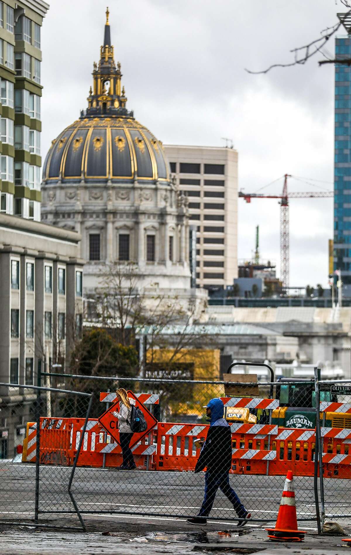 People pass by construction on Van Ness Avenue in San Francisco, California, on Wednesday, March 6, 2019.