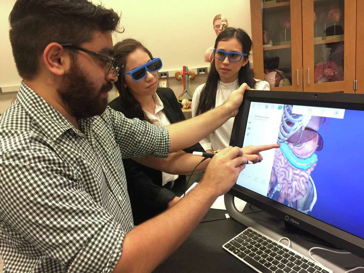 UTSA students Apurva Rawal, from left, Lindsey Gutierrez, and Michelle Gamboa use the zSpace virtual reality program to look at an image. At a virtual reality anatomy conference at UTSA on March 14, 2019, premed and predental students could virtually dissect organs using 3D technology.
