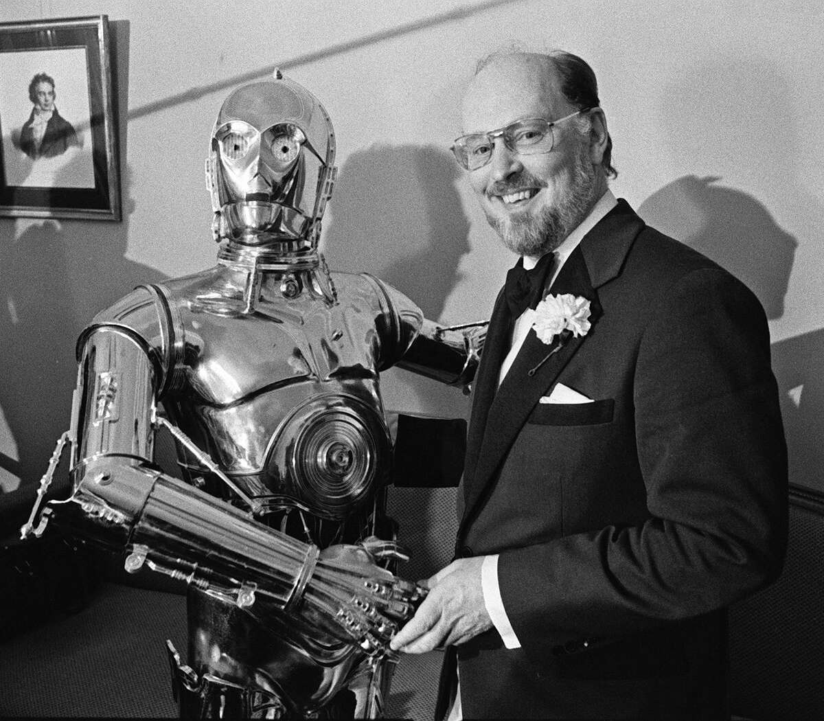** FILE **Boston Pops conductor John Williams, right, shakes hands with "Star Wars" character C-3PO at a news conference in this April 30, 1980 file photo, in Boston. When Williams started working with producer George Lucas on "Star Wars," America was celebrating its bicentennial. The composer was 44, balding with dark hair around the sides and graying beard. The five-time Oscar winner is now 73, with white hair and beard, but the force is still with him. (AP Photo/FILES)