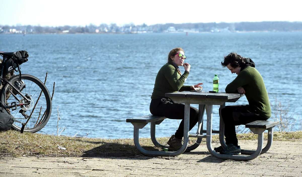 Emily Wasem (left) and Dylan Packard take a break at Long Wharf Park in New Haven while on the first leg of their bicycle trip from Cheshire to Princeton Junction, New Jersey, on March 11, 2019. Wasem is from Princeton Junction, New Jersey, and Packard is from Kensington, New Hampshire.