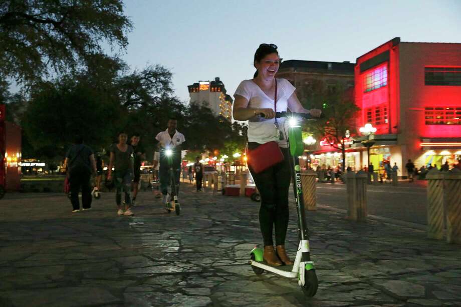 Lime scooter riders use the sidewalk of Alamo Plaza. The rental requires consent to an 18,404-word agreement, longer but similar to virtually every scooter company. Photo: Jerry Lara, Staff Photographer / © 2019 San Antonio Express-News