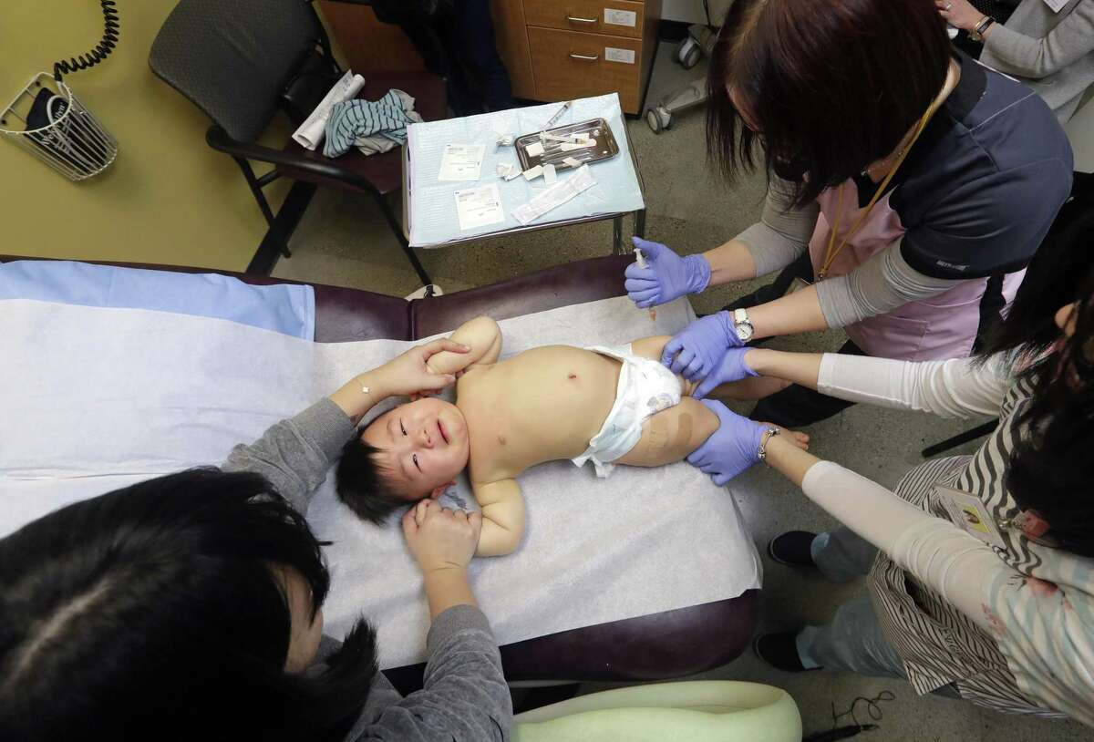 Able Zhang, 1, receives the last of three inoculations, including a vaccine for measles, mumps, and rubella at the International Community Health Services on Feb. 13, 2019, in Seattle. A recent measles outbreak has sickened more than 50 people in the Pacific Northwest, most in Washington state and, of those, most are concentrated in Clark County, just north of Portland, Ore. Washington Gov. Jay Inslee declared a state of emergency over the outbreak last month.