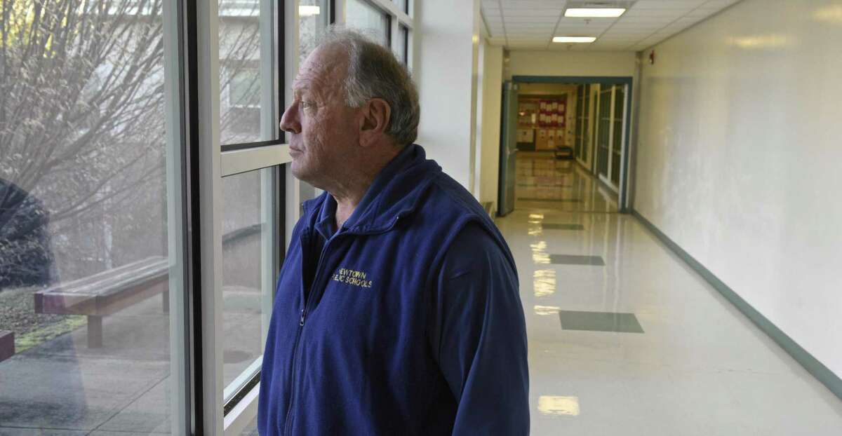 Jim Pacific, an armed school security guard, looks out one of the hallway windows at Reed Intermediate School, in Newtown on Tuesday.
