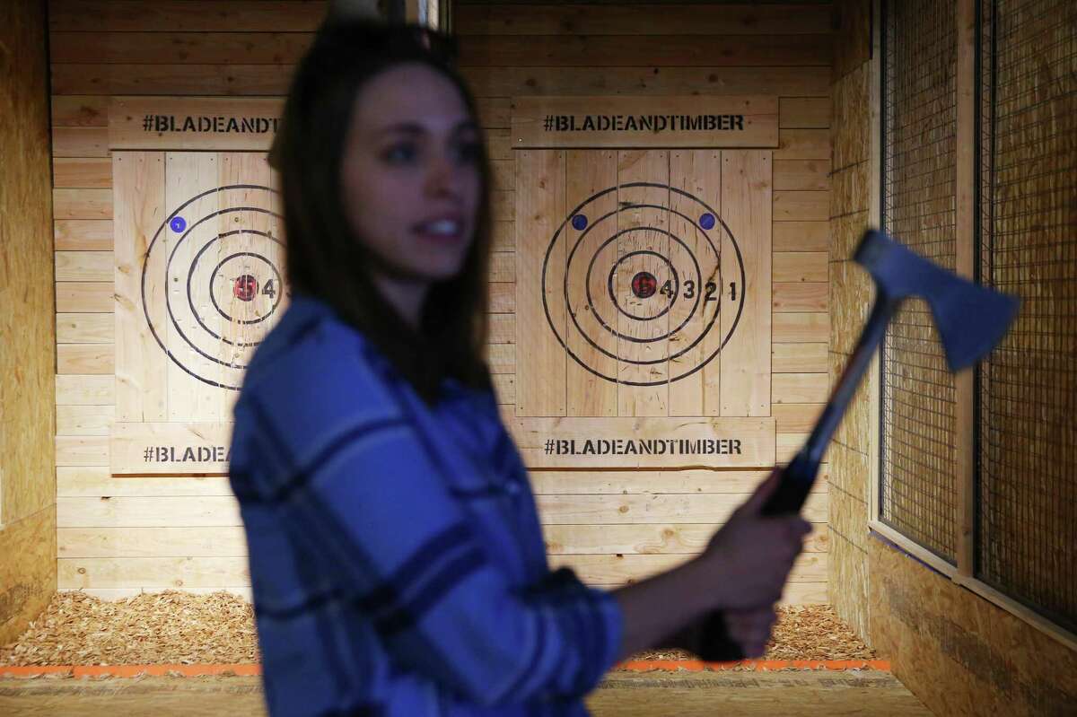 Communications director Jessie Poole demonstrates how to throw an axe at the new axe throwing range opening in Capitol Hill this week, Blade and Timber. The Broadway spot will have throwing lanes available for public and private rental and will eventually serve food and drinks.
