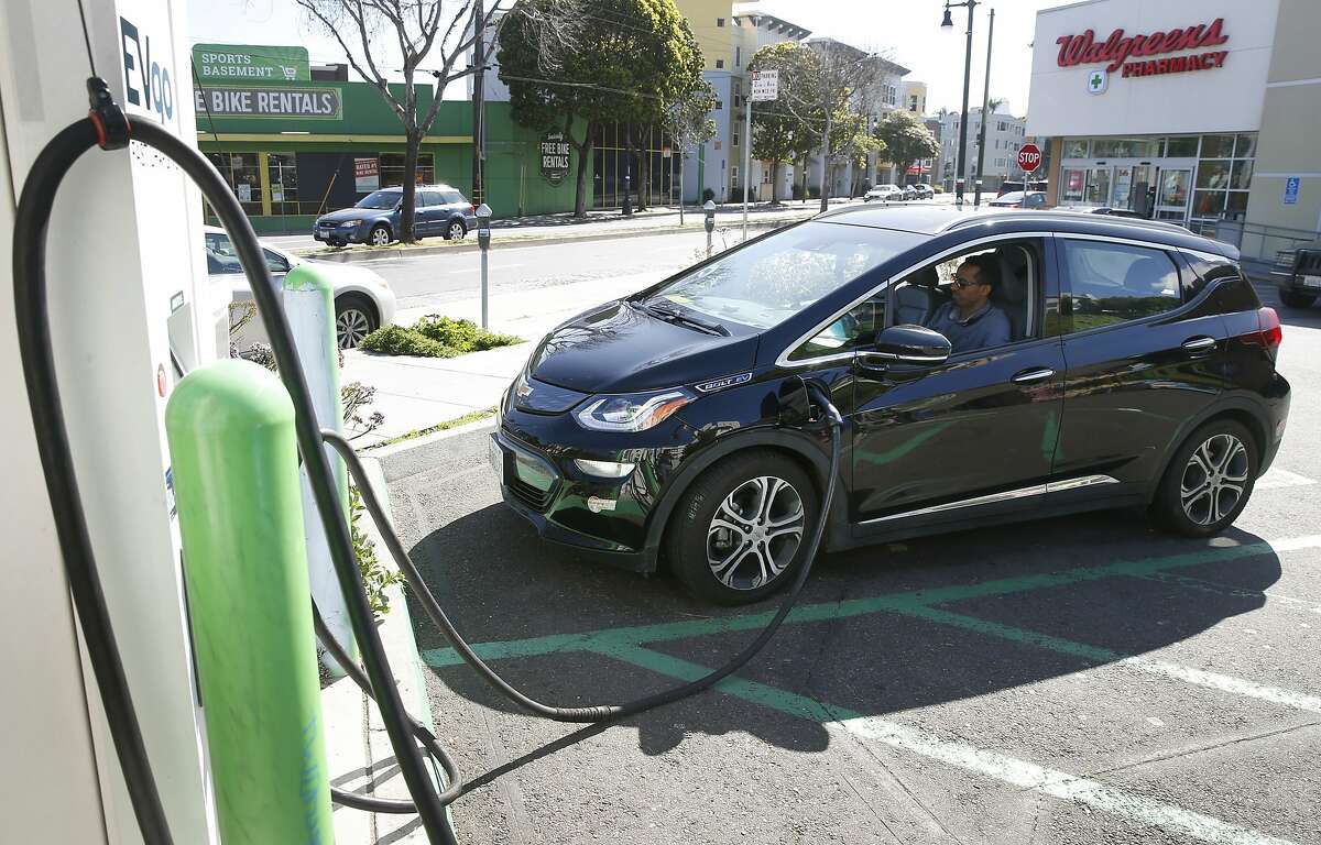 Uber driver Aradom Asfha waits in his Chevrolet Bolt electric vehicle while it’s plugged into a recharging station at Columbus and Bay streets in San Francisco, Calif. on Thursday, March 21, 2019.