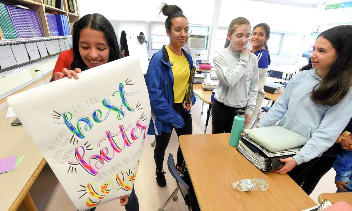 Seventh-grader Stephanie Salinas, left, holds a quote she won in class following a team building classroom exercise "Would you Rather" in Alisha Barry's AVID class at Western Middle School in Greenwich, Connecticut on March 8, 2019.