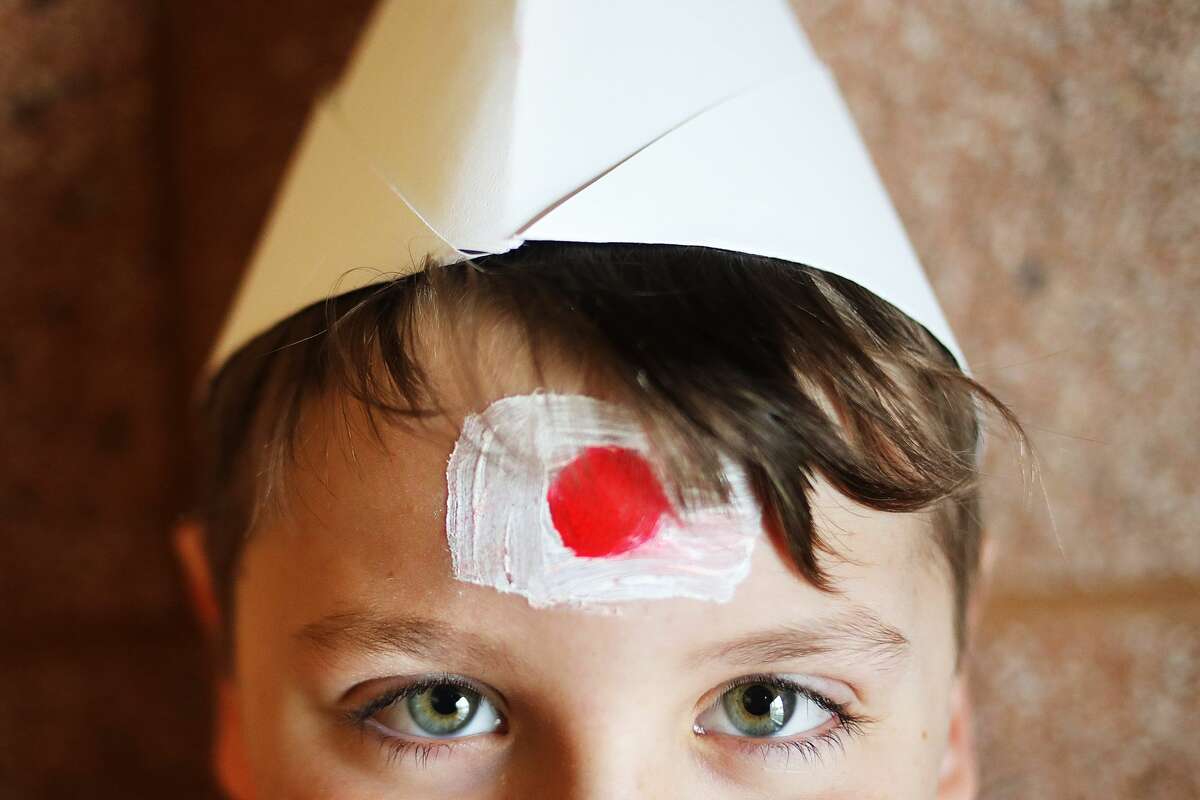Benjamin Angel, 9, wears a hat he made, inspired by traditional hats worn in Kyrgyzstan, and a Japanese flag on his forehead during the Passport to the World international fair held at SVSU on Friday, March 22, 2019. Fourth graders from Chestnut Hill and Bangor Lincoln schools attended the event, which celebrated cultures from around the world. (Katy Kildee/kkildee@mdn.net)