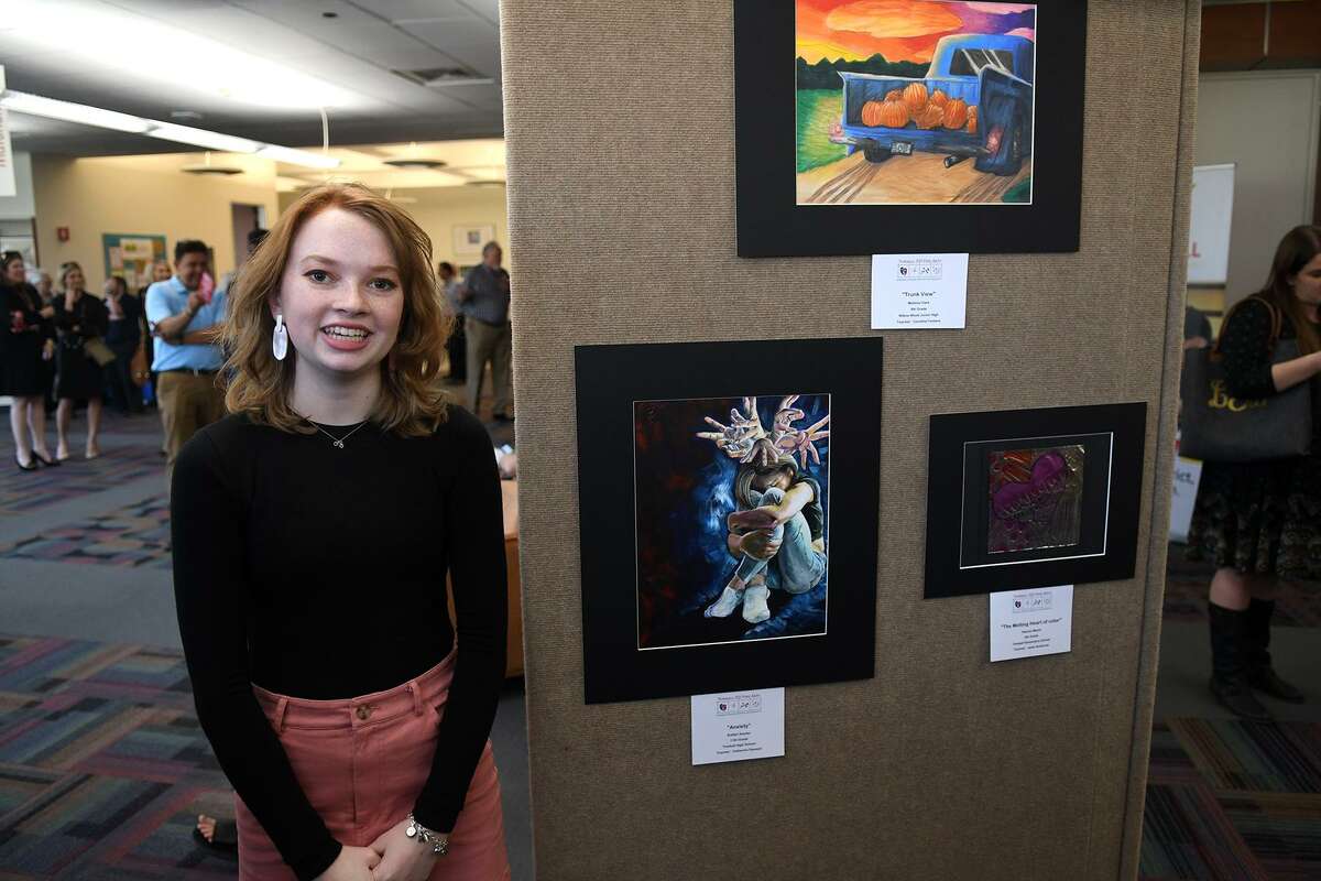 Kaitlyn Snyder, 17, a junior at Tomball High School, poses with her peice, entitled "Anxiety", during the grand opening and celebration of the Tomball Community Art Showcase at the Lone Star College-Tomball Community Library on March 21, 2019.