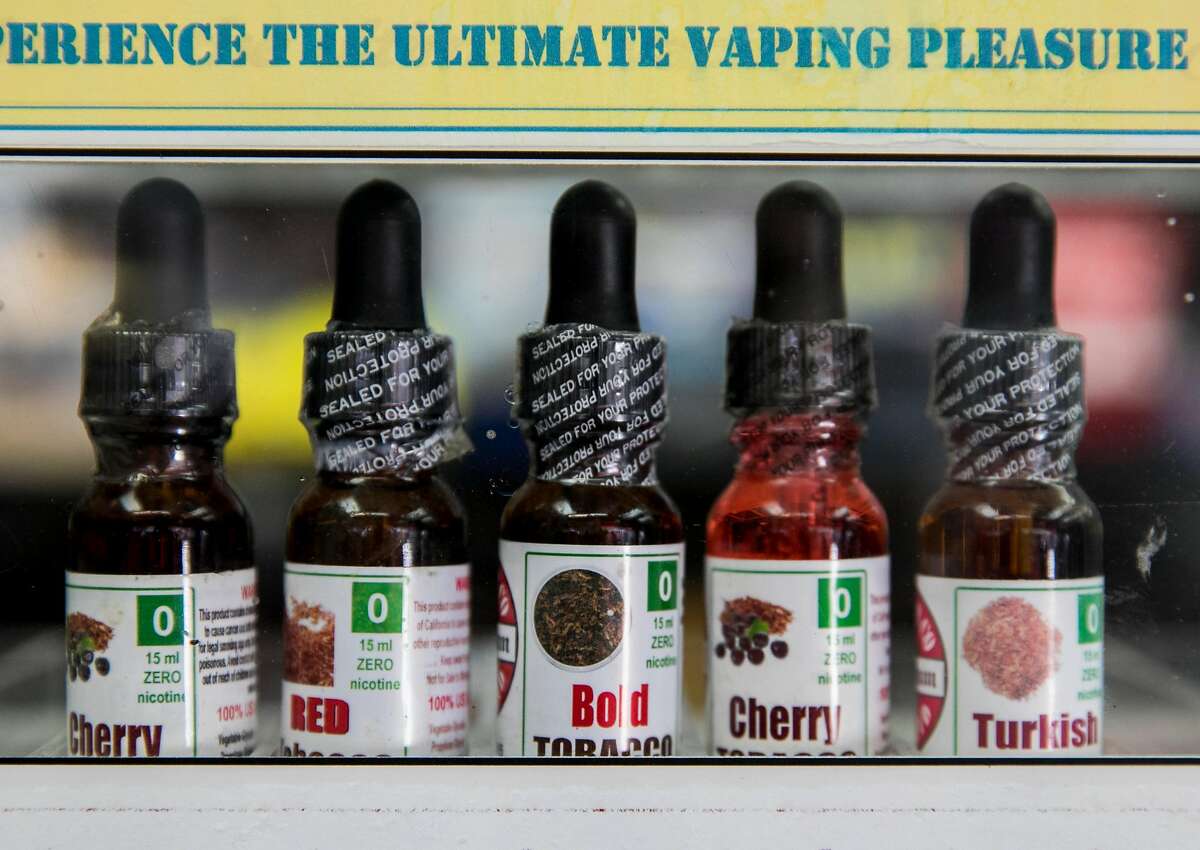 Various e-cigarette juices are seen behind the counter of The Town Smoke Shop in the Mission district of San Francisco, Calif. Thursday, March 21, 2019.