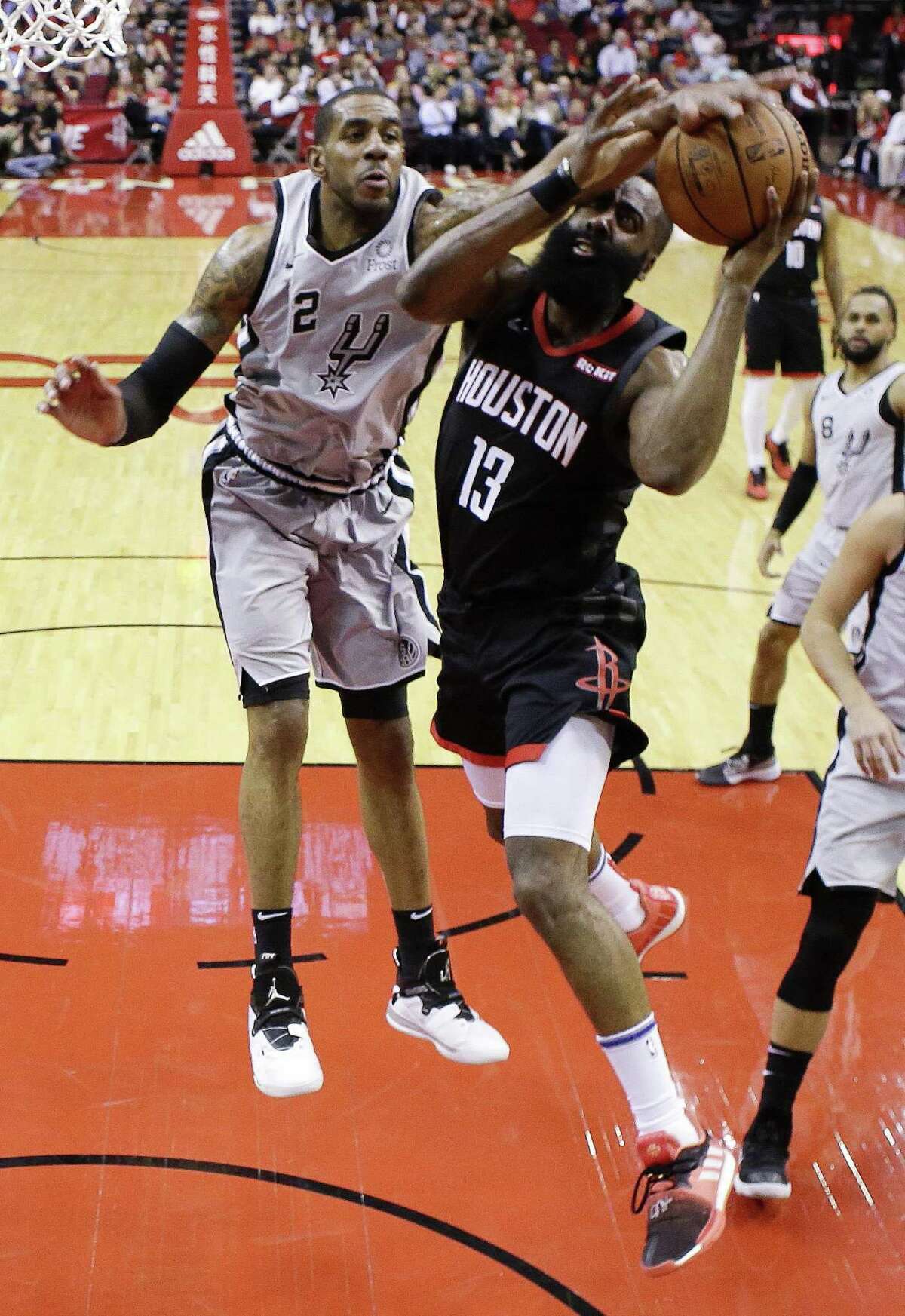 Houston Rockets guard James Harden (13) drives to the basket as San Antonio Spurs center LaMarcus Aldridge defends during the first half of an NBA basketball game Friday, March 22, 2019, in Houston. (AP Photo/Eric Christian Smith)