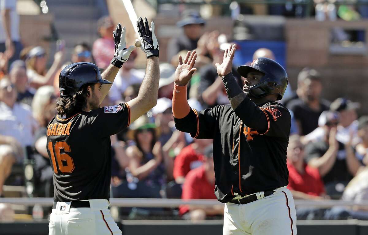 San Francisco Giants' Pablo Sandoval, right, shares congratulations with Aramis Garcia after both scored against the Arizona Diamondbacks in the fourth inning of a spring training baseball game Saturday, March 23, 2019, in Scottsdale, Ariz. (AP Photo/Elaine Thompson)