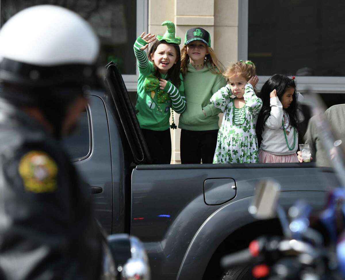 Greenwich girls, from left, Hayden Hickox, 8, Eliza Cornelius, 7, Izzy Cornelius, 5, and Lokshme Anthony, 4, wave and cover their ears as Greenwich Police on motorcycles pass by in the annual St. Patrick's Day Parade in Greenwich, Conn. Sunday, March 24, 2019. Presented by the Greenwich Hibernian Association, the parade featured Irish bagpipe music, Irish dancers, floats from many local organizations, as well as Greenwich police, fire and EMS. Monsignor J. Peter Cullen, from St. Michael the Archangel Parish in Greenwich, served as the parade's Grand Marshal.