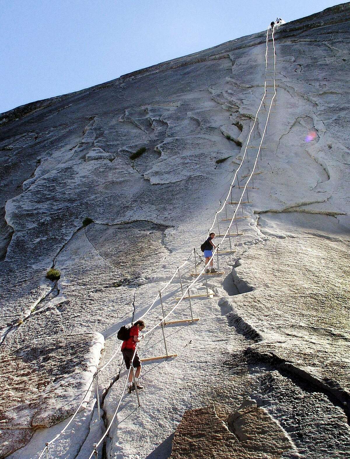 Hikers decend the cable route after climbing to summit of Half Dome, June 6, 2004, in Yosemite National Park. In 1875 George Anderson first climbed this route by drilling holes in the granite and attaching ropes to pull himself to the summit. The park has maintained permanent cables here since 1919. (AP Photo/Robert F. Bukaty)